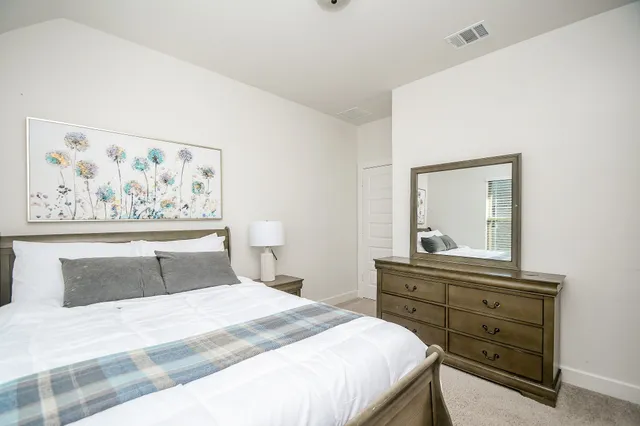 a bedroom with a bed and painting on the wall