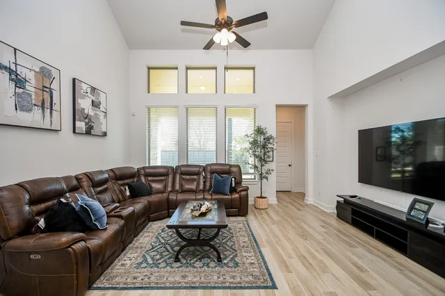 a living room with furniture a flat screen tv and a window