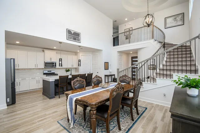 a kitchen with a table chairs stainless steel appliances and cabinets