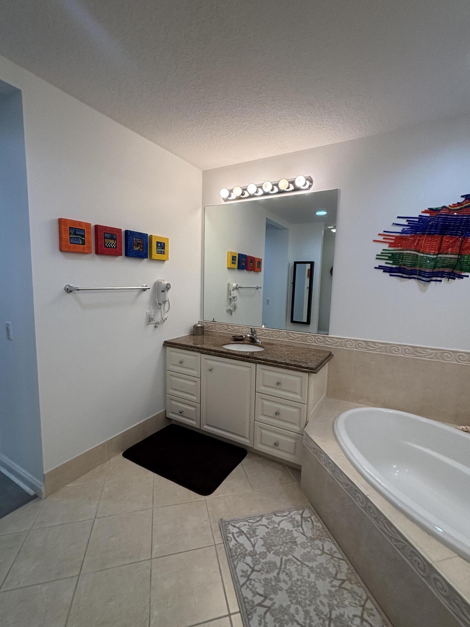9 Harbour Isle Drive East, Unit 102 Fort Pierce, FL 34949 - Photo 23 of 30 a bathroom with a tub sink and mirror