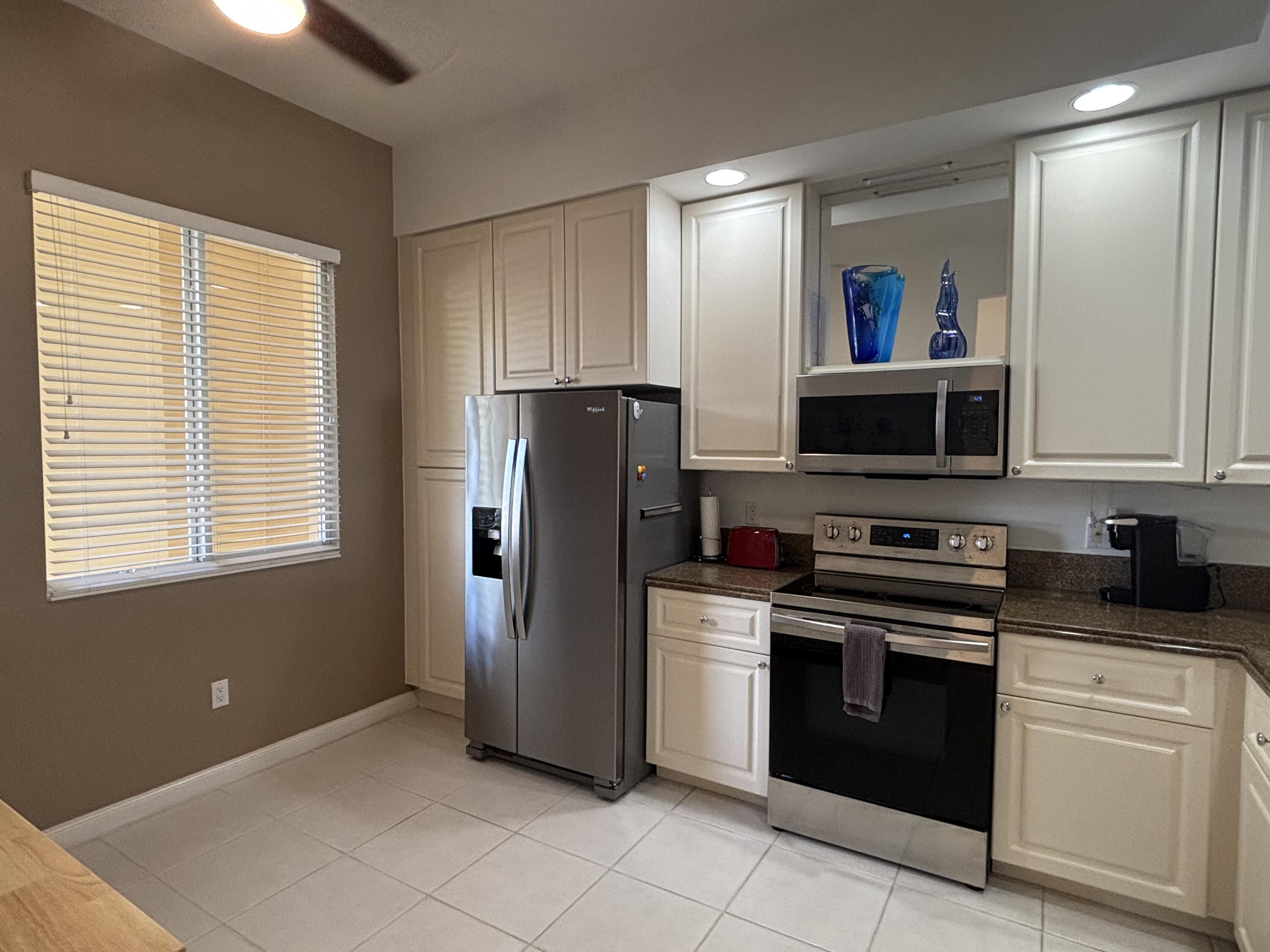 9 Harbour Isle Drive East, Unit 102 Fort Pierce, FL 34949 - Photo 4 of 30 a kitchen with a refrigerator sink and microwave