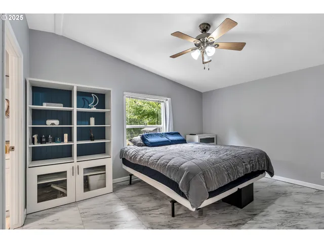 a bedroom with a bed and a ceiling fan