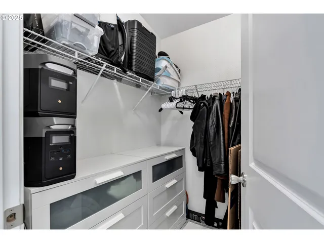 a view of walk in closet with clothes and shoes