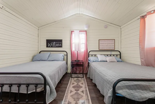 a bedroom with two beds and painting on the wall