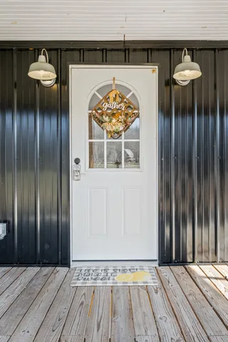 a view of a livingroom with wooden floor and next to a fireplace