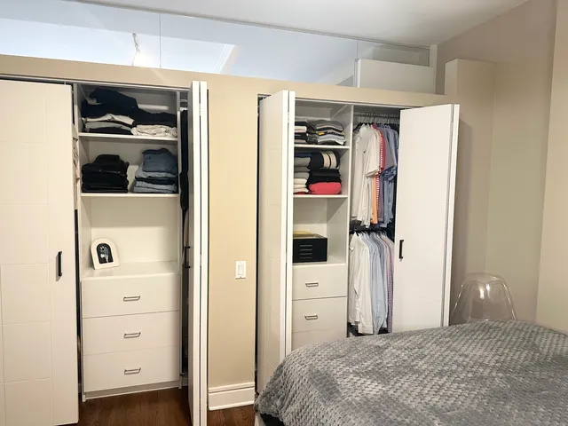a bedroom with a bed and a refrigerator