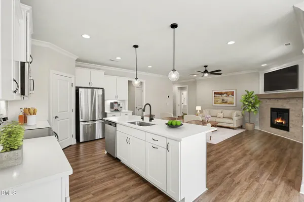 a kitchen with stainless steel appliances kitchen island granite countertop a refrigerator a oven a stove and a sink with wooden floor