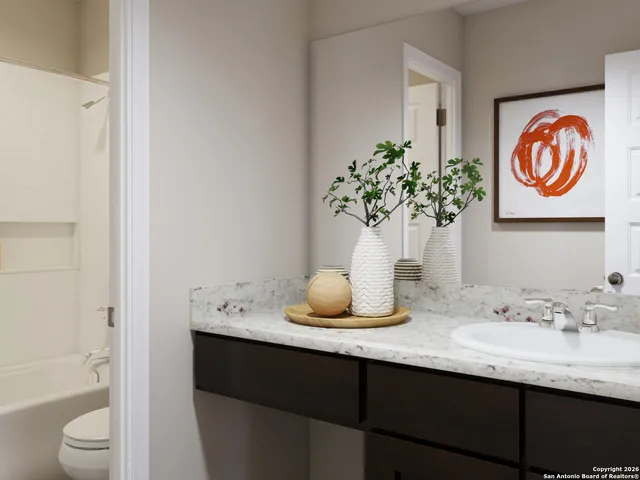 a bathroom with a granite countertop sink and a mirror