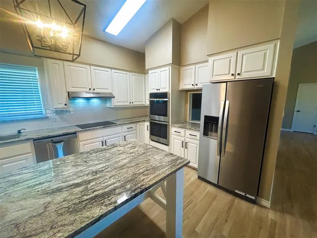 a kitchen with stainless steel appliances granite countertop a sink and a stove