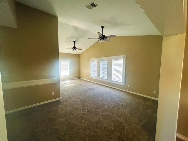 en empty room with windows and ceiling fan