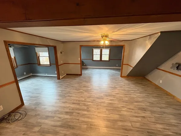 an empty room with wooden floor and windows