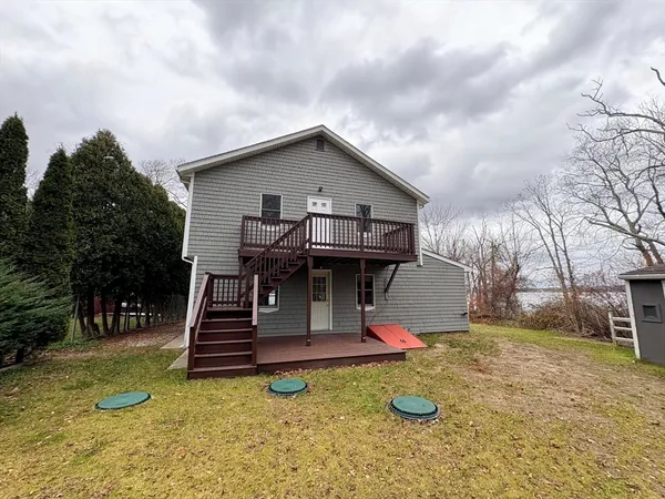 a view of a house with backyard and a tree