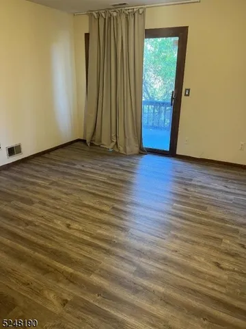 a view of a room with wooden floor and a window