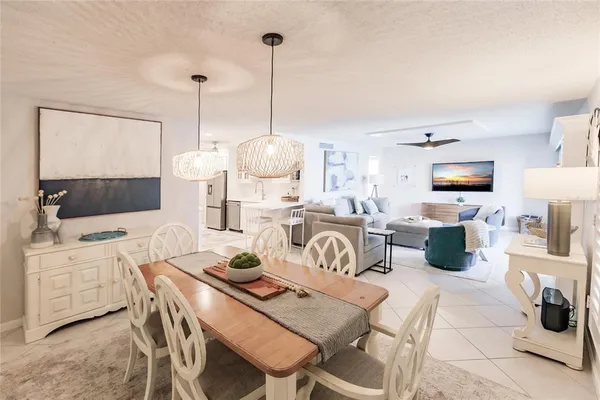 a living room with furniture a flat screen tv and kitchen view