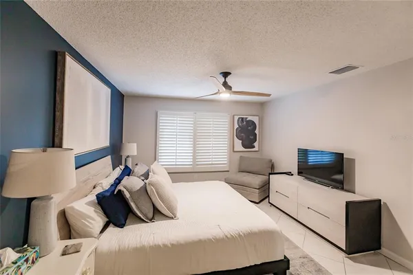 a bedroom with a bed and large window