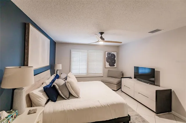 a bedroom with a bed and large window