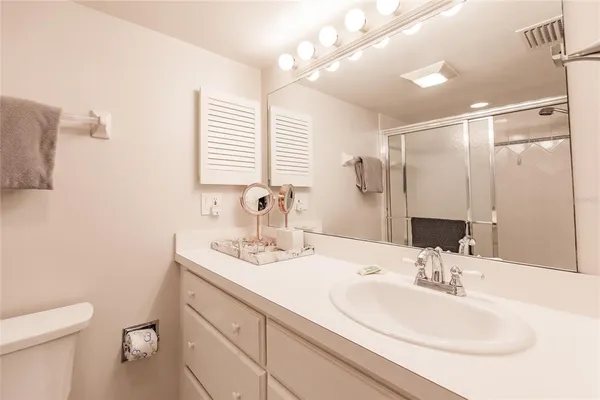 a bathroom with a sink toilet double vanity and shower