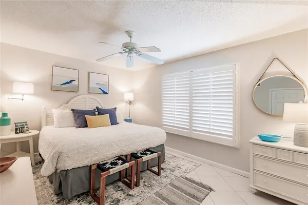 a bedroom with a bed a dresser and next to a window