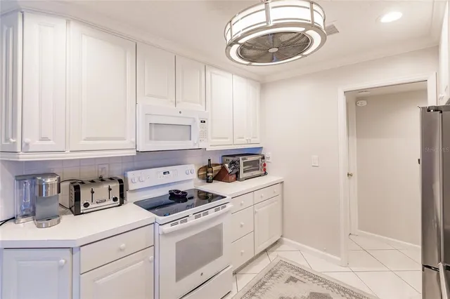 a kitchen with white cabinets and white appliances
