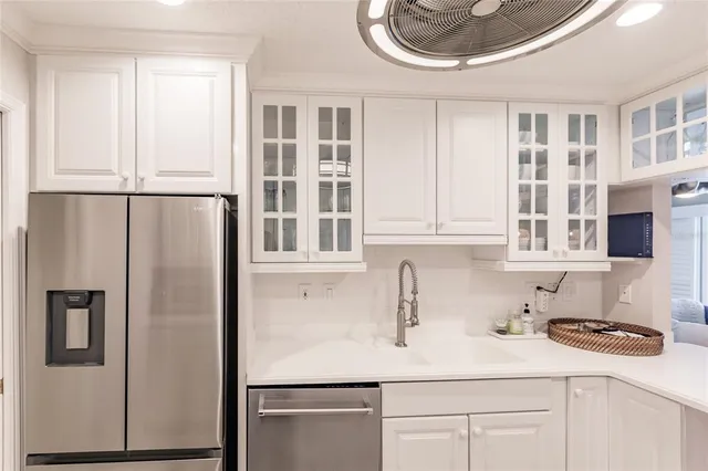 a kitchen with stainless steel appliances a sink a refrigerator and a cabinets