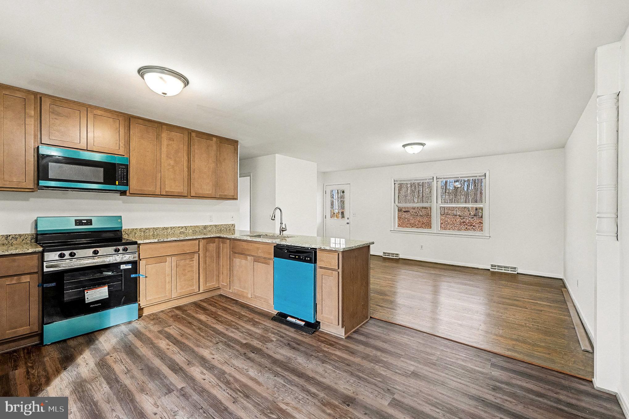 4127 Cabin Road Reva, VA 22735 - Photo 12 of 28 a kitchen with granite countertop wooden floors and stainless steel appliances