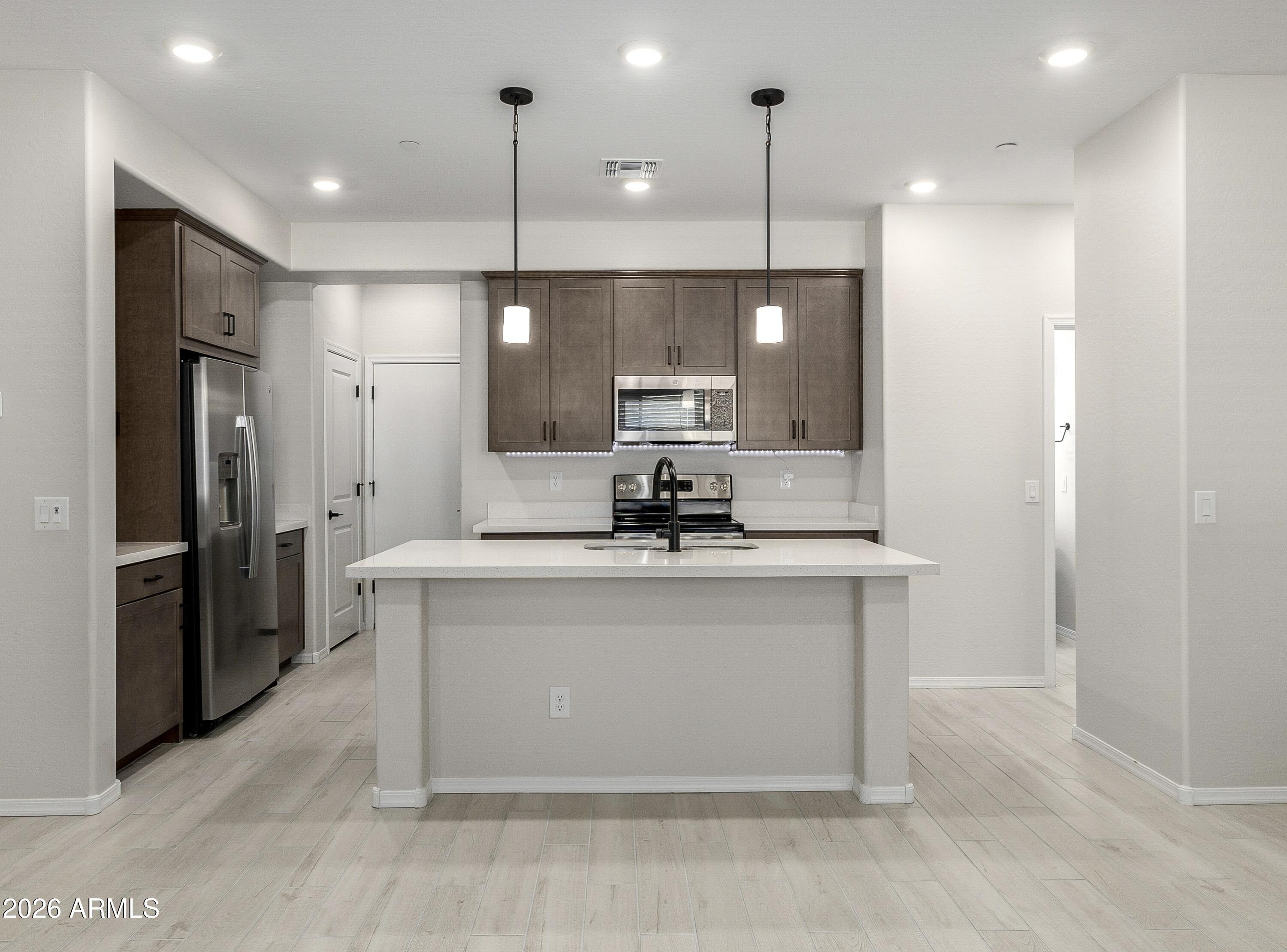 1850 East Bernie Lane, Unit 102 Gilbert, AZ 85295 - Photo 1 of 62 a view of a kitchen with a sink stainless steel appliances and cabinets