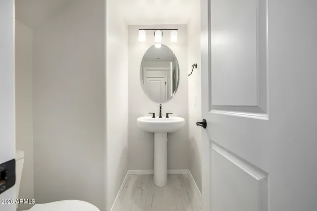 a bathroom with a toilet a sink and mirror
