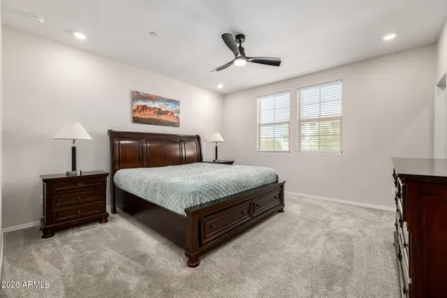 a bedroom with a bed and a ceiling fan