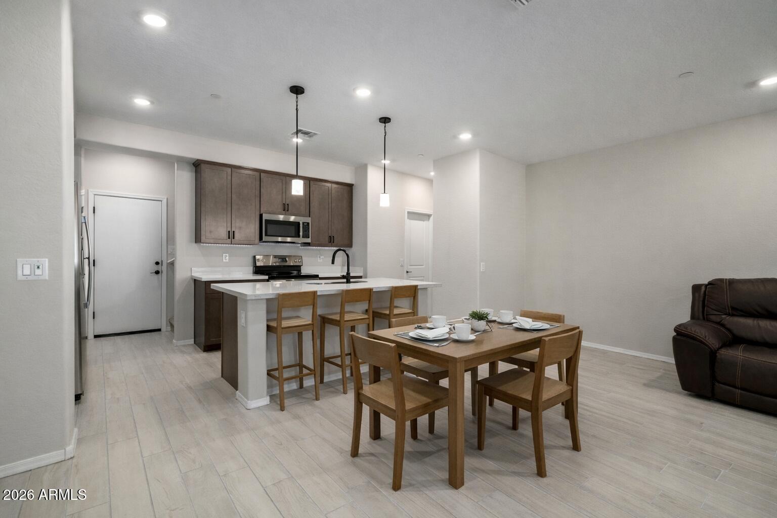 1850 East Bernie Lane, Unit 102 Gilbert, AZ 85295 - Photo 3 of 62 a kitchen with refrigerator and chairs