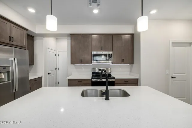 a kitchen with kitchen island a sink stainless steel appliances and cabinets