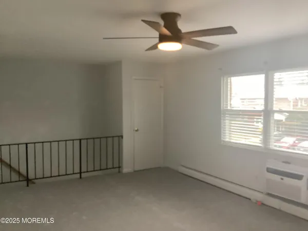 a view of a livingroom with a ceiling fan and window