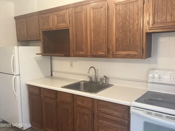 a kitchen with stainless steel appliances wooden cabinets a sink and a microwave