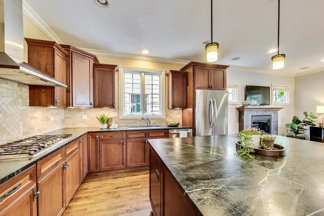 a kitchen with stainless steel appliances granite countertop a sink stove and refrigerator
