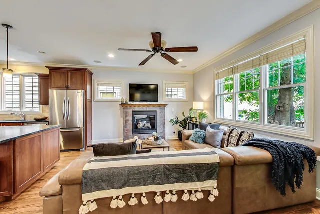 a bed sitting in a spacious bedroom next to a window and a chandelier