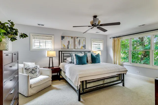 a bedroom with a bed couch and potted plant