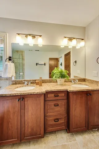 a bathroom with a granite countertop sink and a mirror