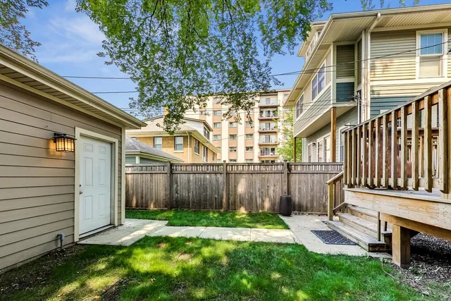 a view of a backyard with plants and wooden fence