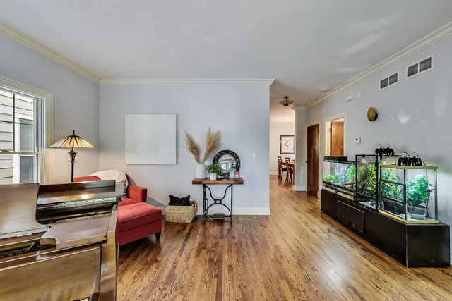 a living room with furniture floor to ceiling window and wooden floor