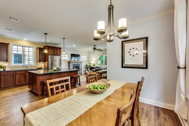a view of a dining room with furniture a chandelier and wooden floor