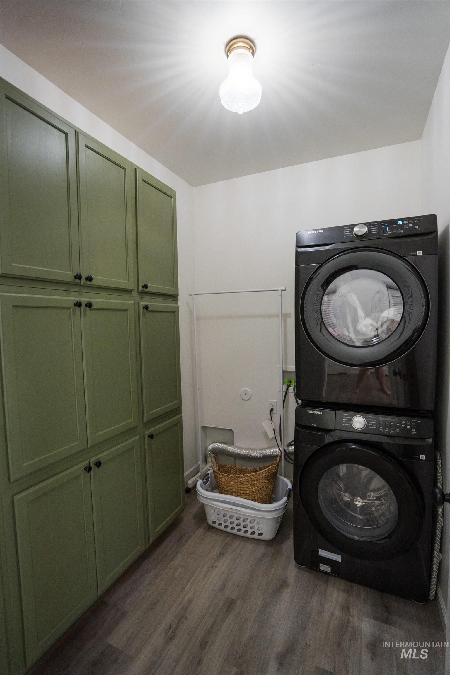 2110 Q Street Heyburn, ID 83336 - Photo 15 of 28 Laundry area featuring stacked washer / dryer, cabinet space, and dark wood-style flooring