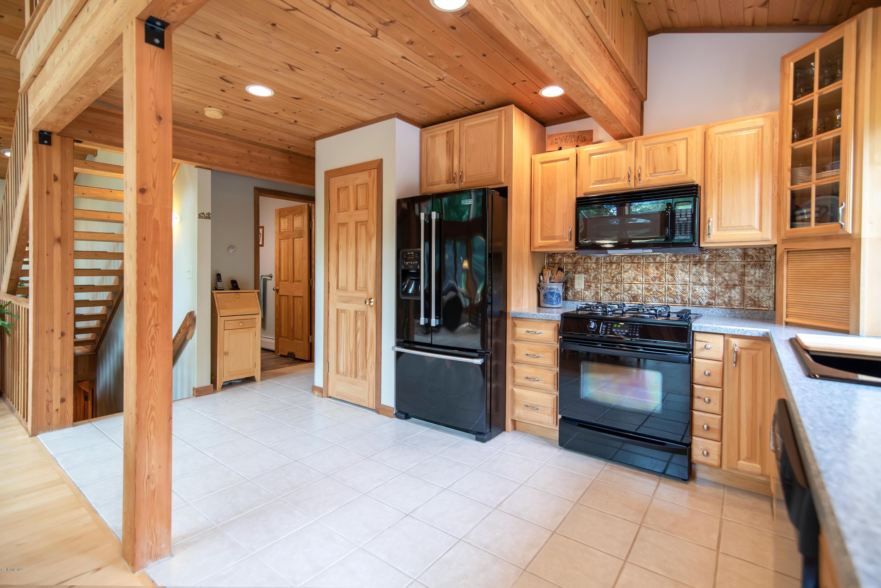 106 Dimmock Road Otis, MA 01253 - Photo 11 of 42 a kitchen with stainless steel appliances granite countertop a refrigerator and a stove top oven