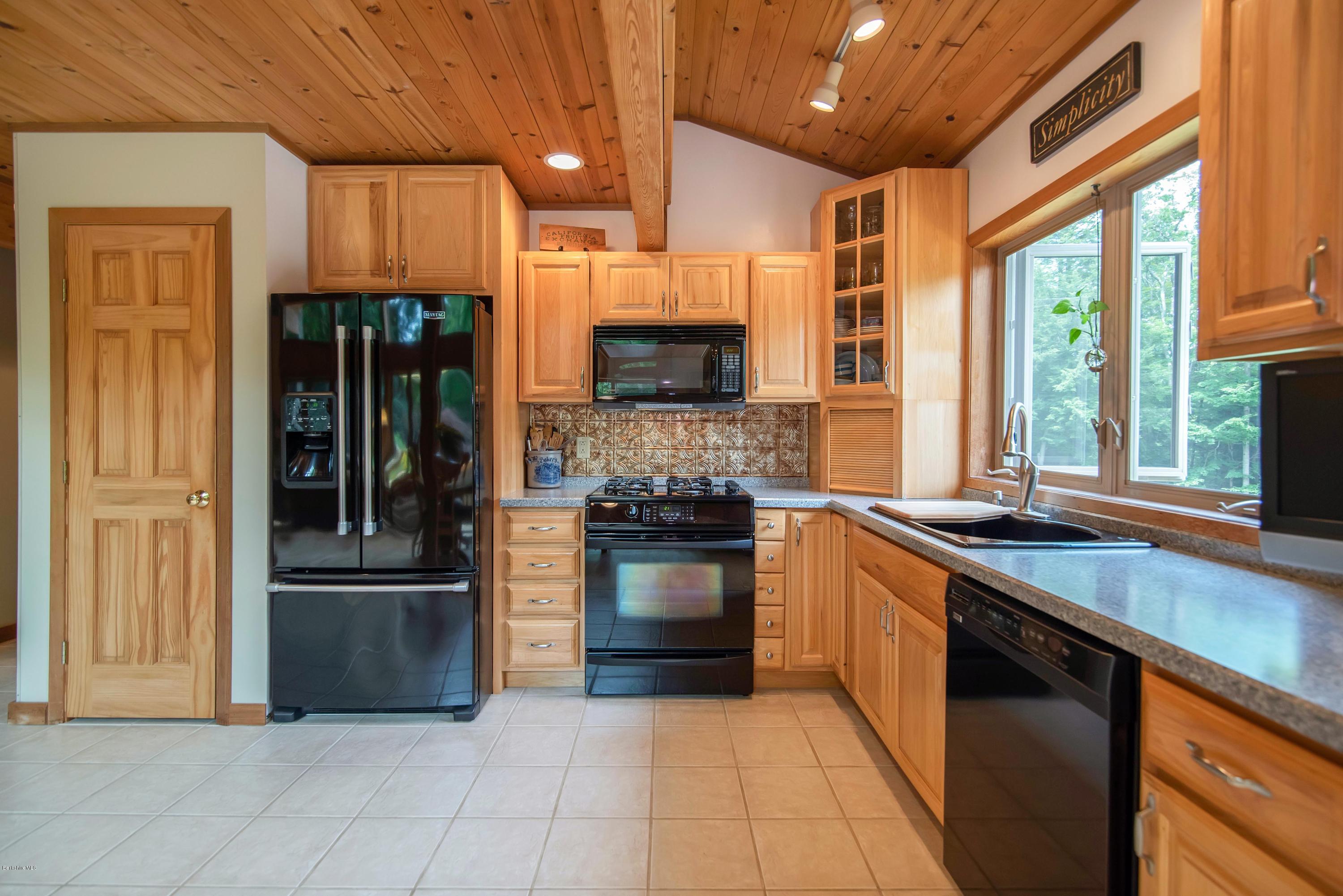 106 Dimmock Road Otis, MA 01253 - Photo 12 of 42 a kitchen with stainless steel appliances granite countertop a refrigerator and a stove top oven