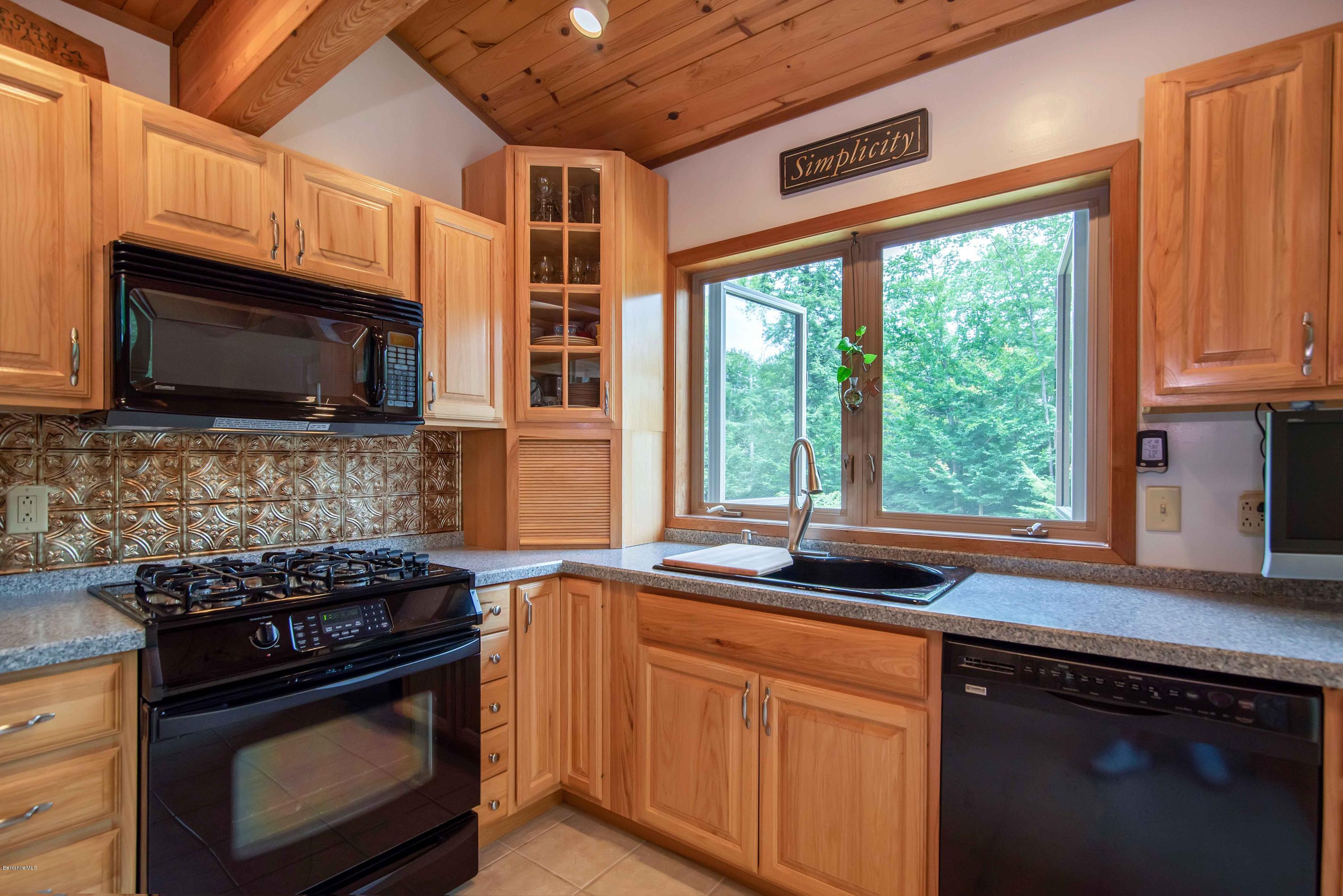 106 Dimmock Road Otis, MA 01253 - Photo 10 of 42 a kitchen with stainless steel appliances a stove sink microwave and cabinets