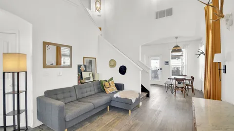 a living room with furniture and a wooden floor