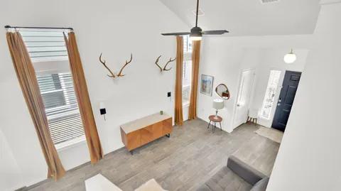 a view of a livingroom with wooden floor and stairs
