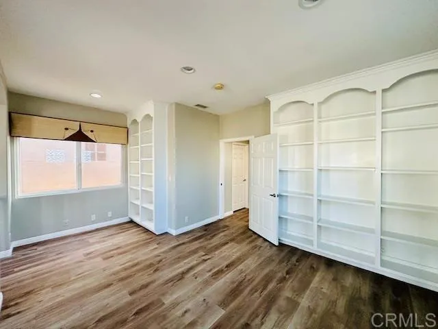 a view of empty room with wooden floor and cabinet