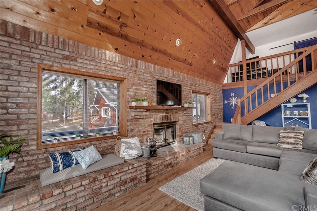 725 Temple Lane Big Bear Lake, CA 92315 - Photo 12 of 65 a living room with furniture a flat screen tv and a floor to ceiling window