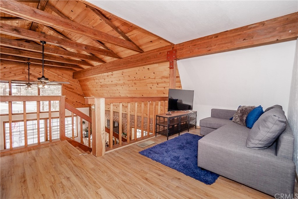 725 Temple Lane Big Bear Lake, CA 92315 - Photo 15 of 65 a living room with furniture a flat screen tv and a floor to ceiling window