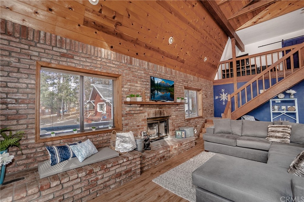 725 Temple Lane Big Bear Lake, CA 92315 - Photo 29 of 65 a living room with furniture a fireplace and a large window