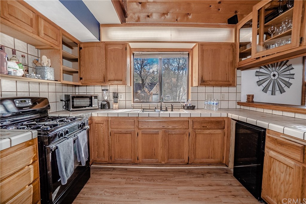725 Temple Lane Big Bear Lake, CA 92315 - Photo 34 of 65 a kitchen with stainless steel appliances granite countertop a stove a sink and a microwave